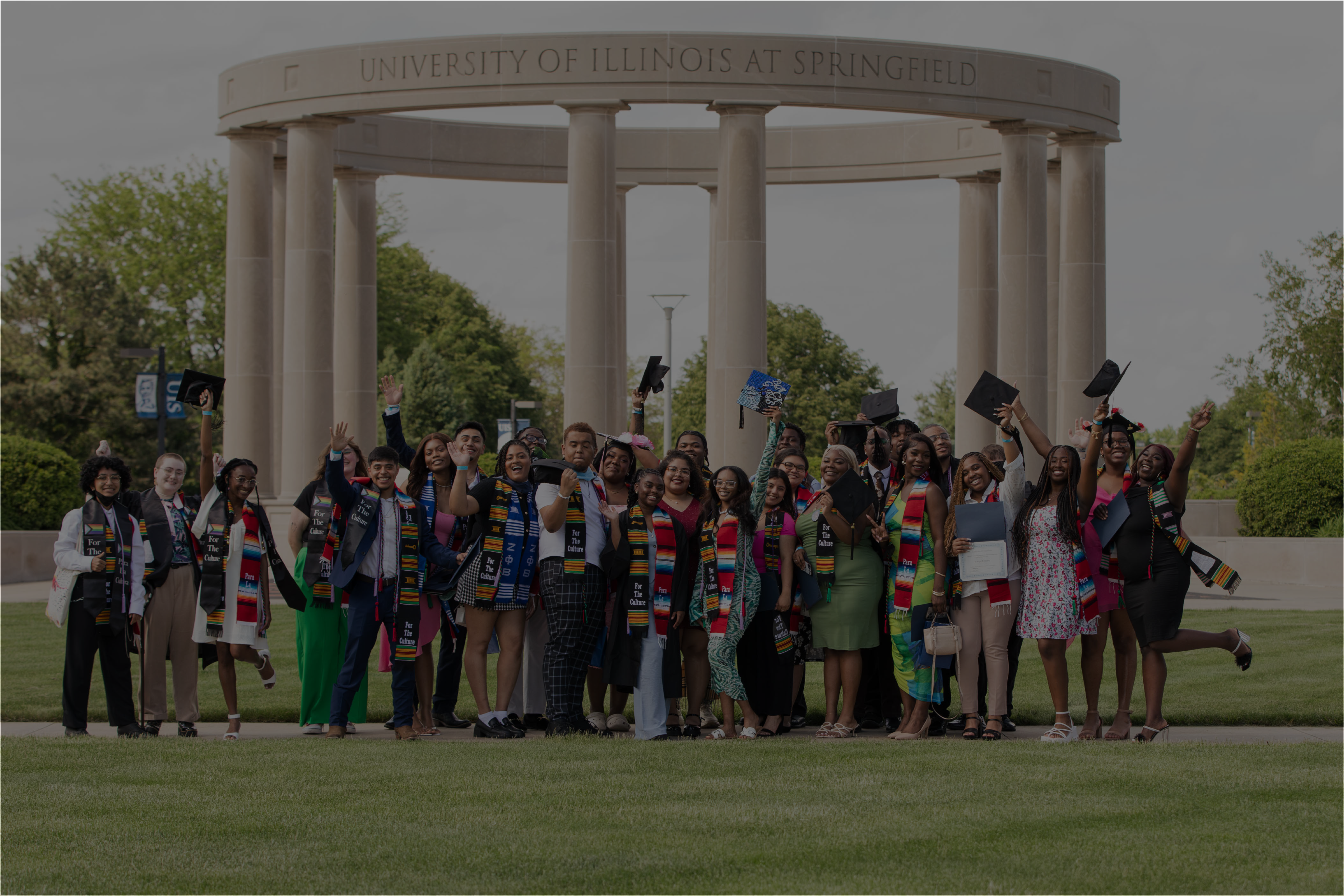 P.R.O.U.D. graduates in front of colonnade celebrating