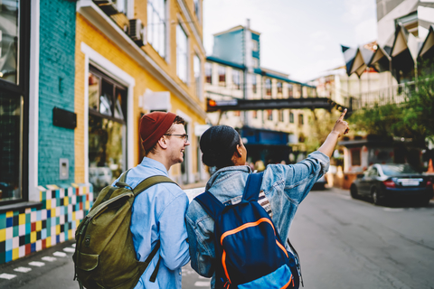 Students exploring a colorful city street with backpacks