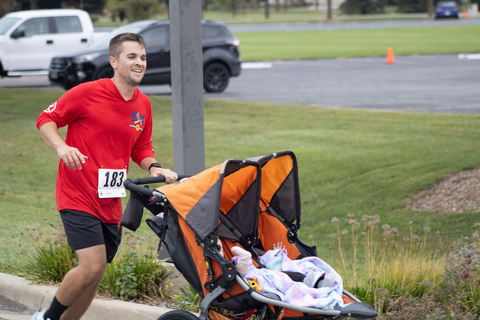 a racer running with their twin stroller