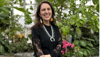 Picture of a woman standing in front of greenery