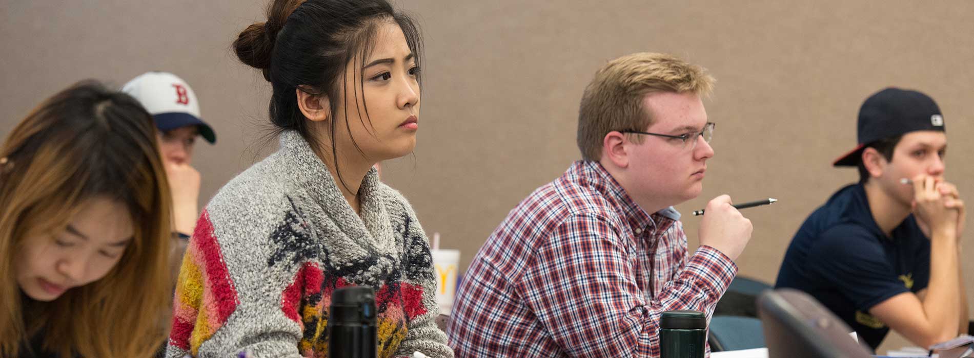 Students attentively listening in a classroom setting.