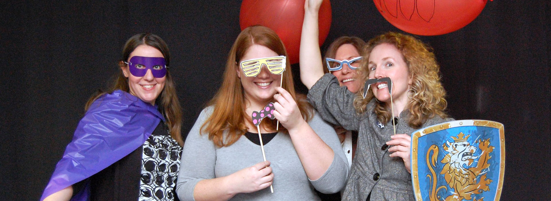 UIS employees posing for silly pictures at picture booth at Alumni campaign event