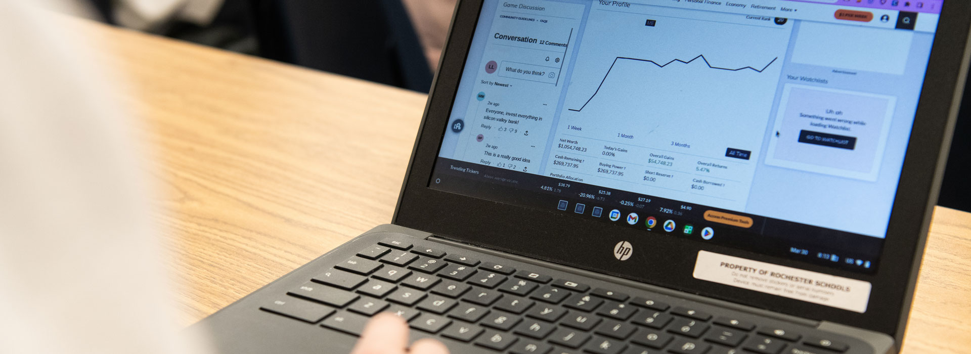 a student at a laptop looking at the stock market