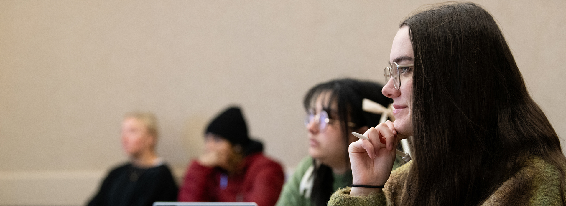 Girl with dark hair paying close attention in class