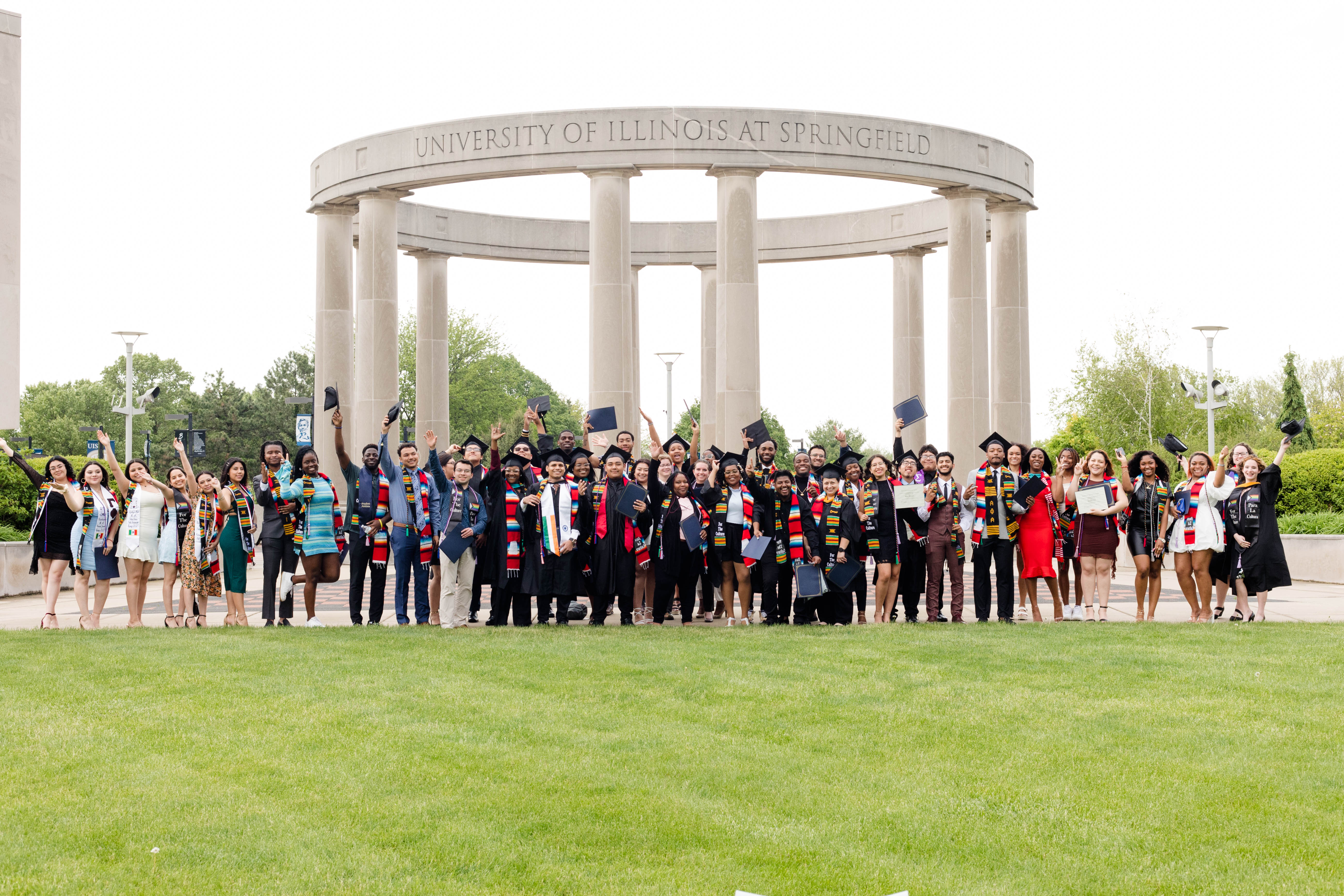 Recent graduates in front of the UIS Colonnade