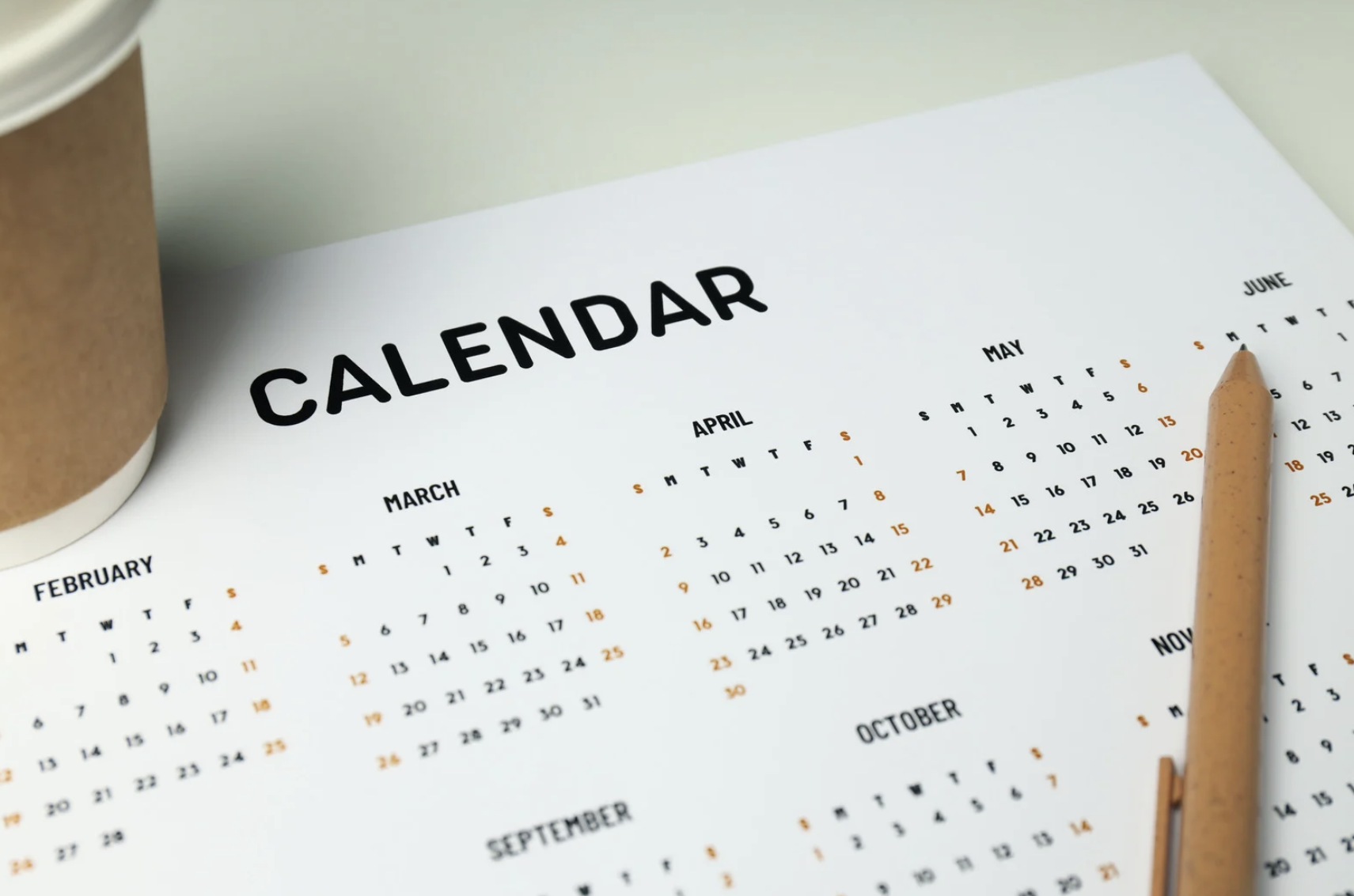 A calendar with a coffee cup and a pen 