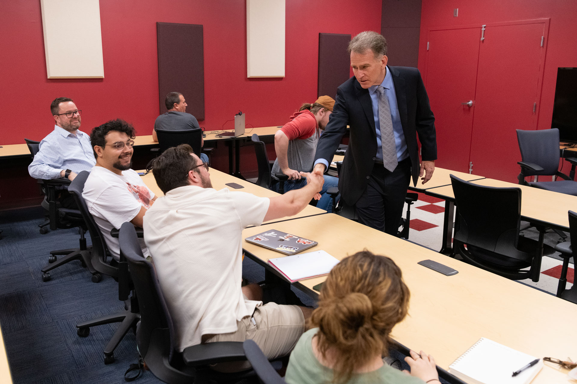 a guest speaker shaking hands with students during a lecture