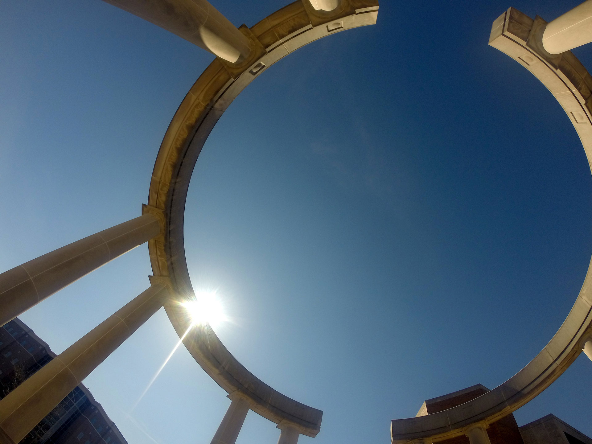 a view of the colonnade looking up to the sky from the ground