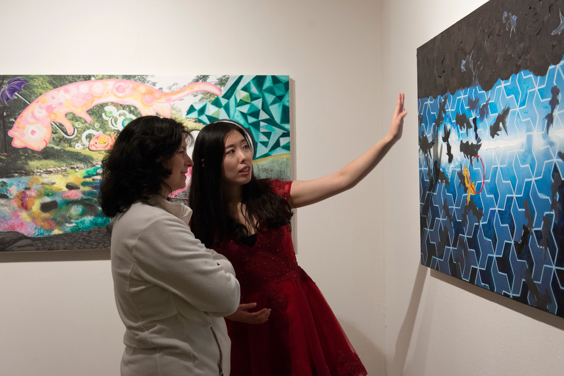 a student showing their artwork to a viewer
