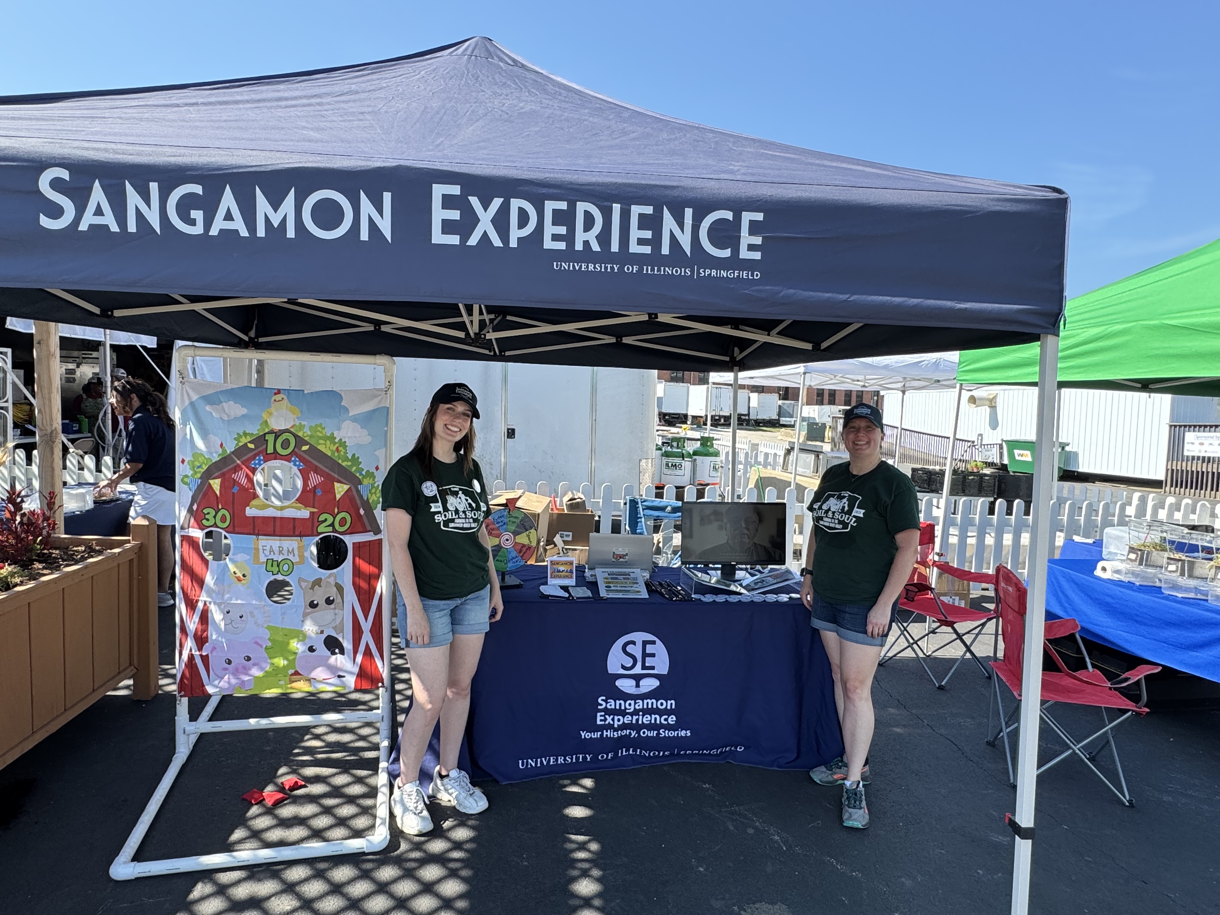 Evie and Anne at the Illinois State Fair under a "Sangamon Experience" tent.
