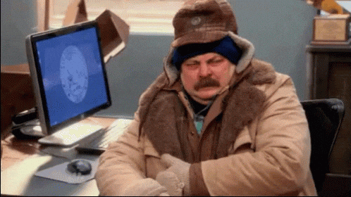 Ron Swanson, from Parks and Rec, shivering in a big coat.