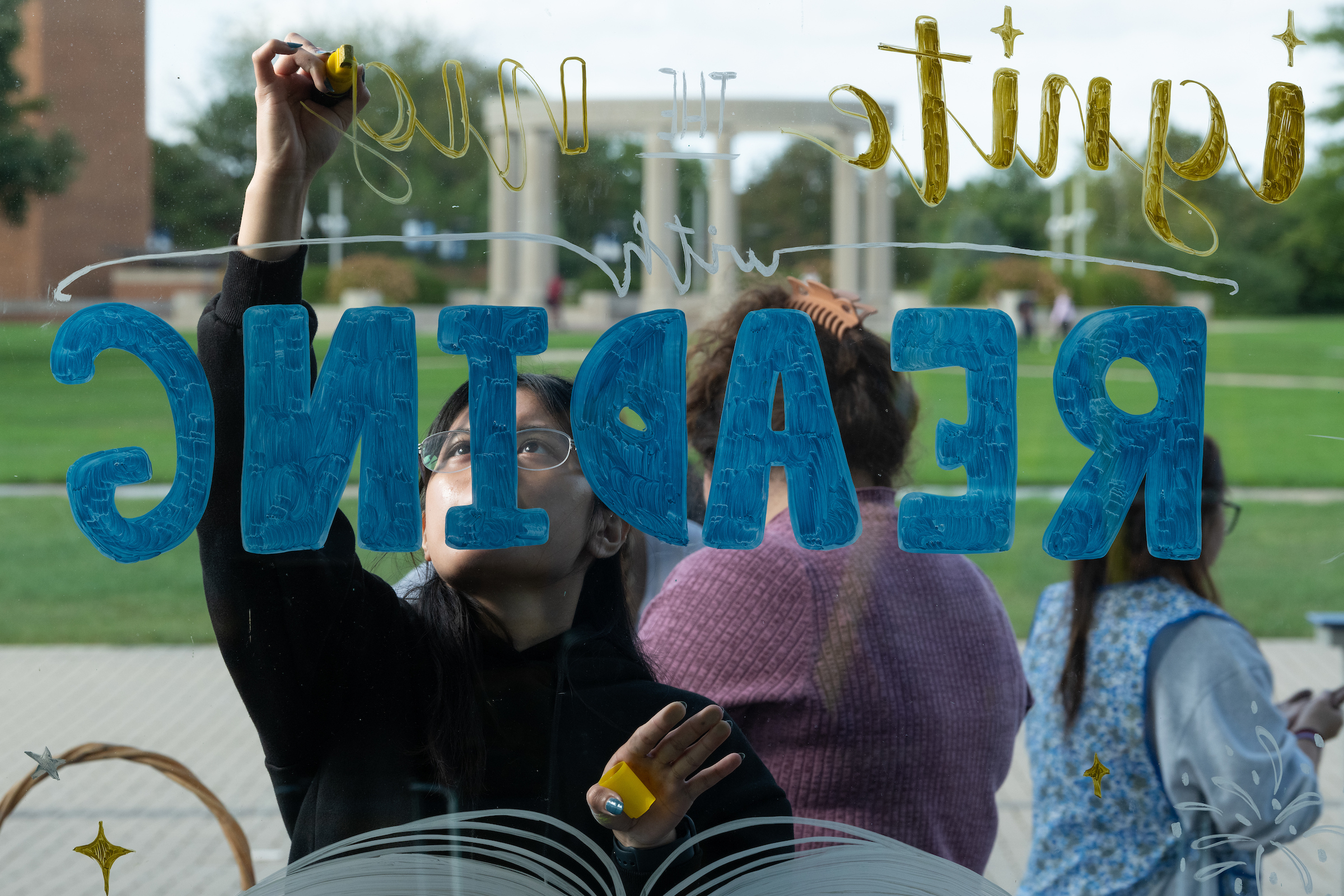 Student painting on student union windows