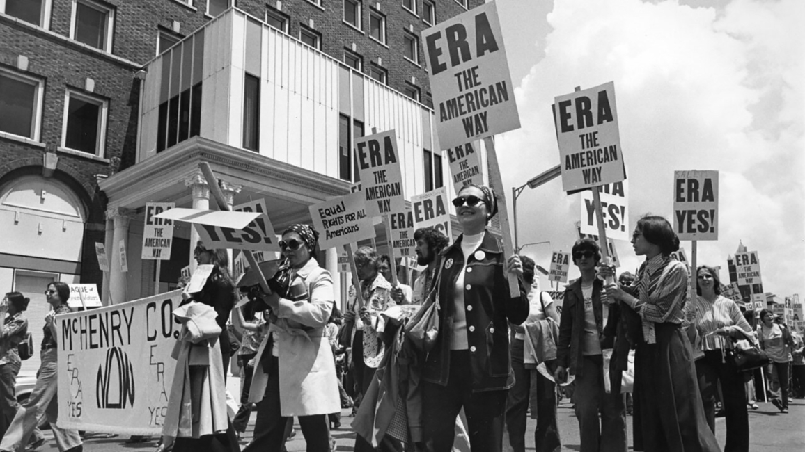 Women holding signs that say "ERA" march through the streets of Springfield in 1982 as part of an Equal Rights Amendment rally.