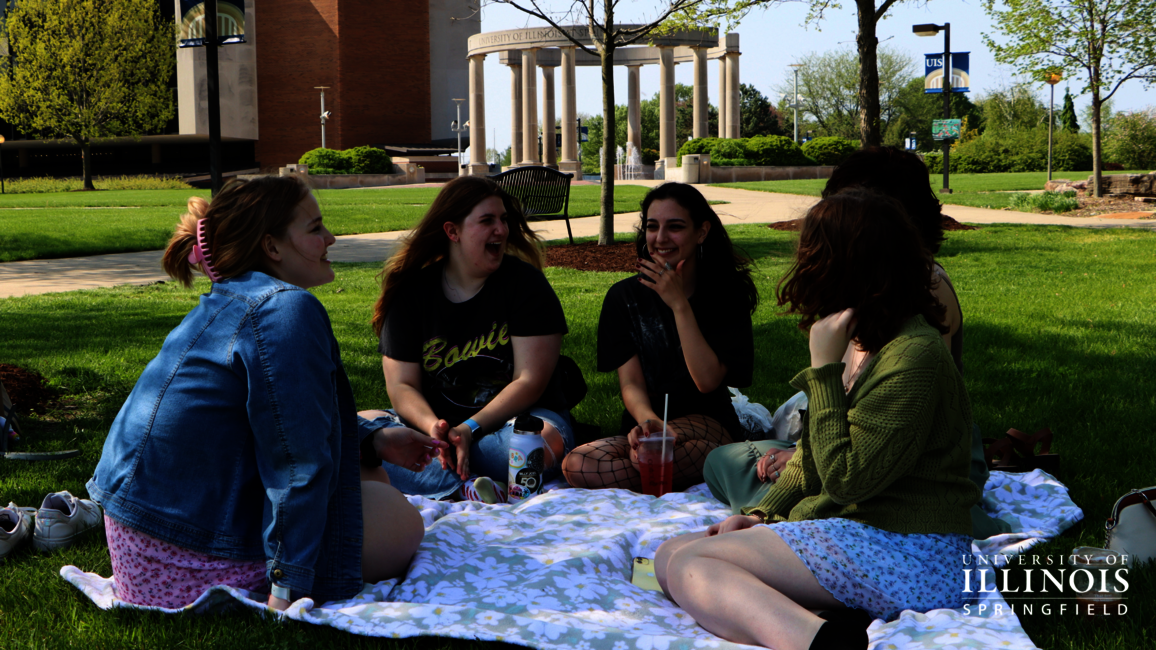 A picture of friends having a picnic on the quad.