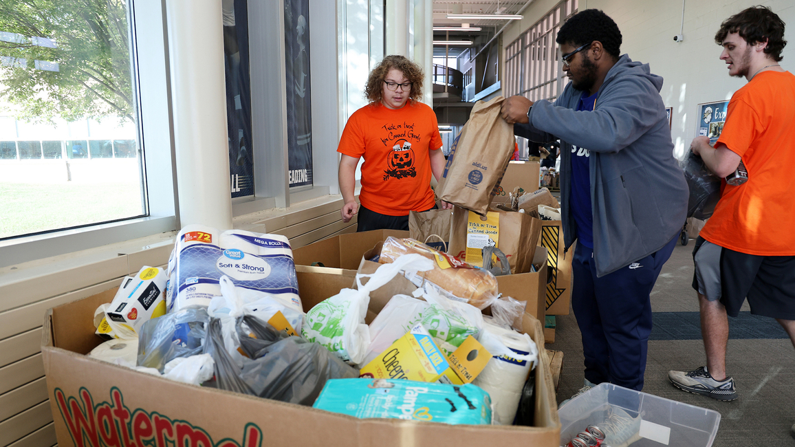 Students put collected food inside bins