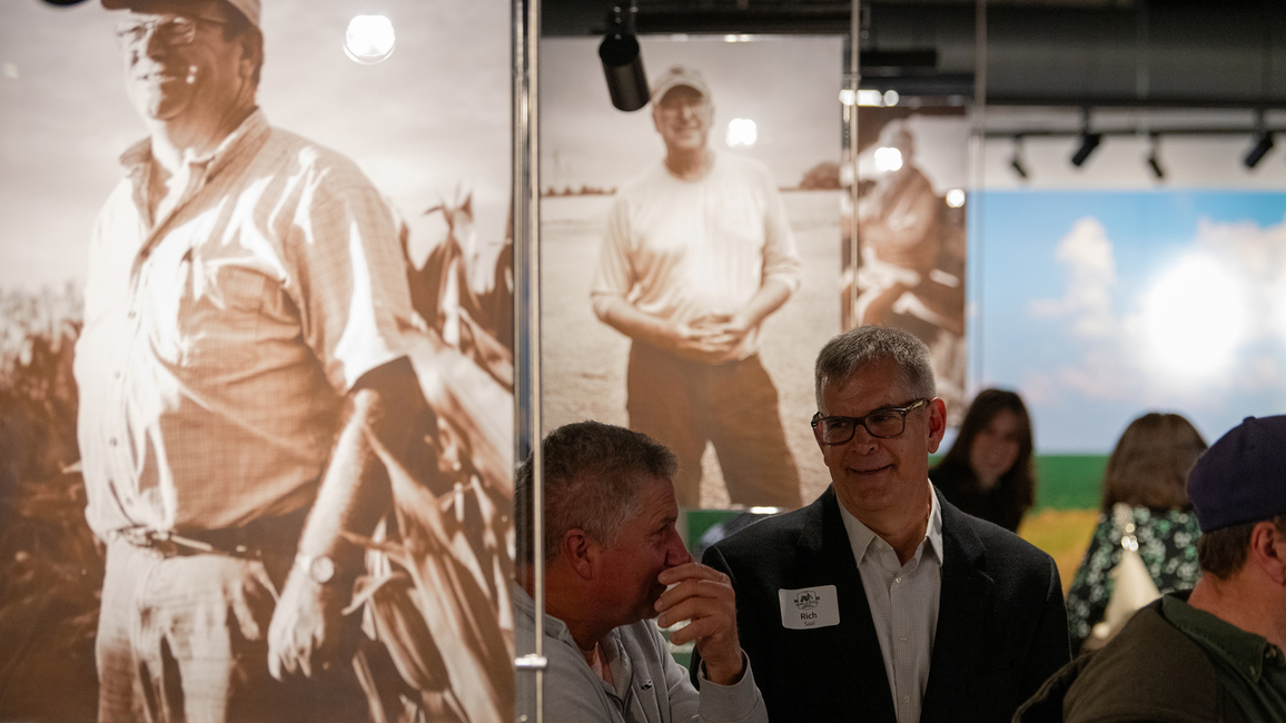 Attendees at the Soil & Soul premiere at UIS in November 2024, with farmer portraits displayed in the background.