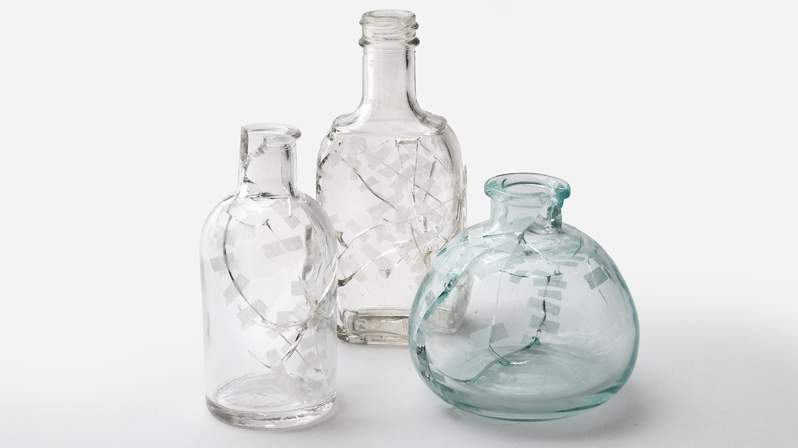  Three uniquely designed glass bottles displayed together, showcasing their distinct shapes and patterns.