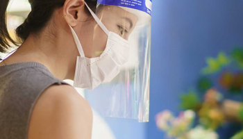 Woman working with mask and face shield