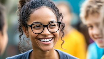 a smiling social worker surrounded by smiling kids