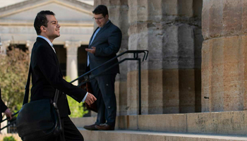 male lawmaker climbing steps of Capitol with a smile on his face