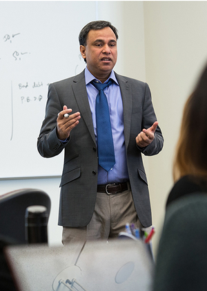 UIS professor Mohammed Mohi Uddin teaching a class using hand gestures in a classroom. 