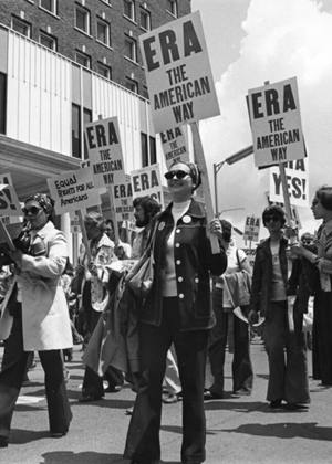 Women holding signs that say "ERA" march through the streets of Springfield in 1982 as part of an Equal Rights Amendment rally.