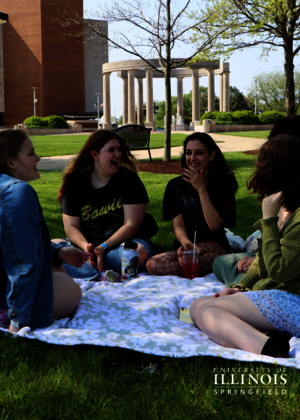 A picture of friends having a picnic on the quad.