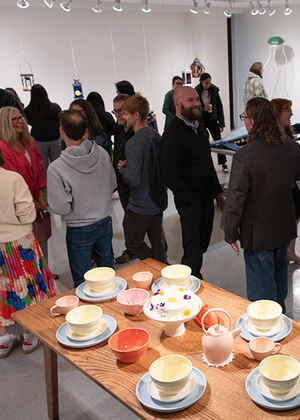 A group of people gathered to view art in the gallery.