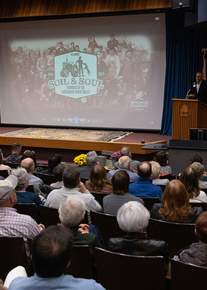 Audience watching the premiere of Soil & Soul at UIS in November 2024, with a speaker at the podium.