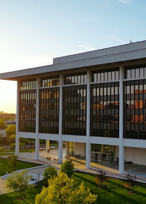 Horace Mann building in downtown Springfield at sunset, with trees and sidewalks in the foreground.