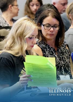 Mother and daughter review paperwork at orientation.