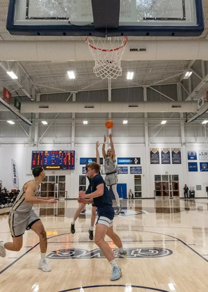 Adidas Davis attempting three-point shot on UIS basketball court