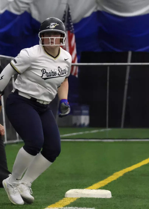 Emme Steward on third base at softball tournament in Springfield Clinic Dome, wearing white and blue UIS Prairie Stars uniform