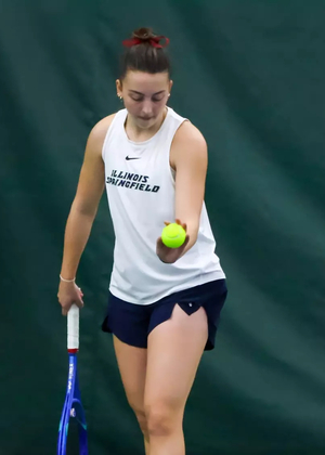 Jane Carter serving in UIS tennis match