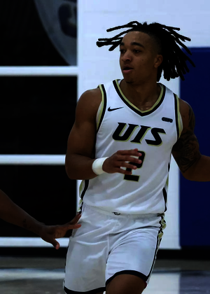 Jordan Rice playing basketball in white UIS uniform