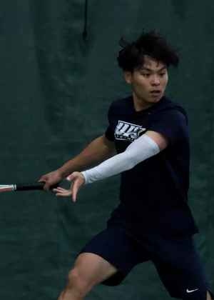 Lin En Tan playing tennis in UIS uniform