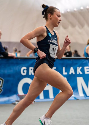 Madelyn Miller-Ross running indoor track in blue UIS uniform