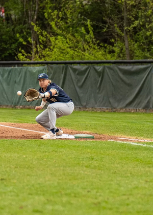 Drew Ezard playing first base in blue UIS baseball uniform