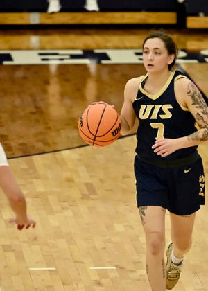 Kennedy Osterman playing basketball in blue UIS uniform
