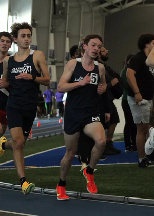 UIS men's track athletes running an indoor race
