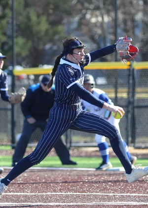 Rosie Bartletti pitching in blue pinstripe UIS softball uniform