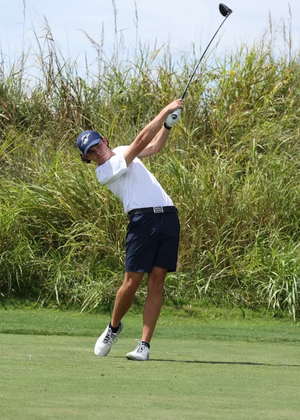 A photo of Jake Balding golfing in a white polo and blue hat