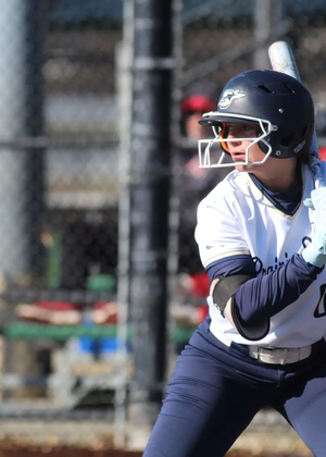 Olivia DeLuca batting in white UIS uniform