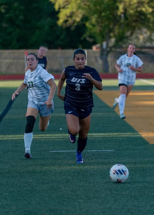 Reese Lowery playing soccer in blue UIS uniform
