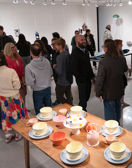 A group of people gathered to view art in the gallery.