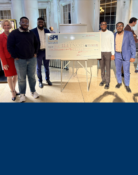 TredBase receives a large check during an event at the Abraham Lincoln Presidential Museum.