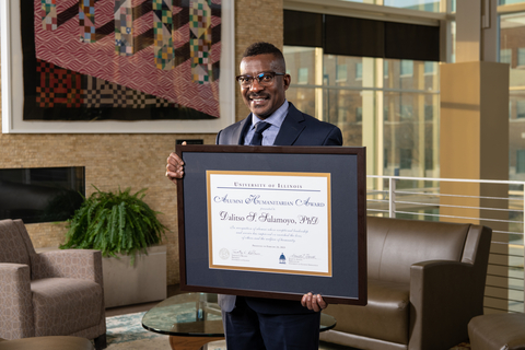 Dalitso Sulamoyo holding his Alumni Humanitarian Award in the Student Union