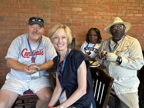 four people sitting around a table pose for a picture