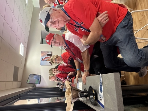 four people sit inside while watching a St Louis Cardinals baseball game