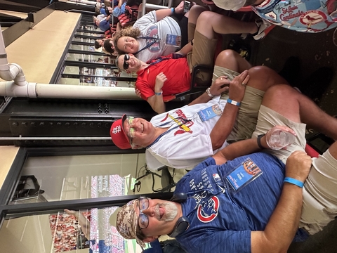 four people sit in the stands at a St Louis Cardinals baseball game